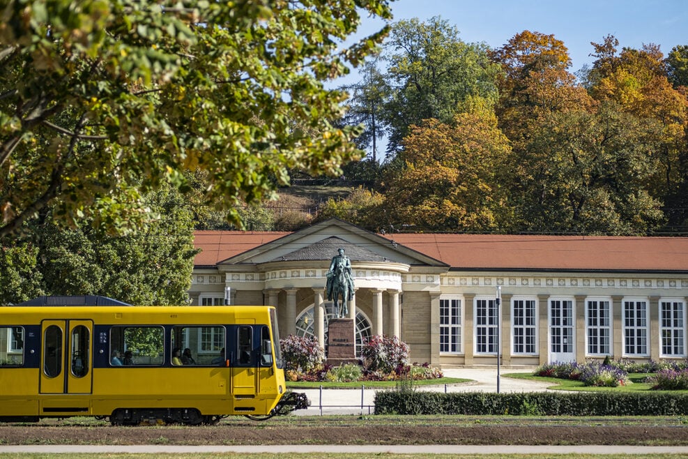 gelbe U-bahn vor historischem Gebäude